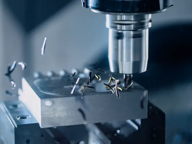 CNC milling machine cutting a steel part, chips flying